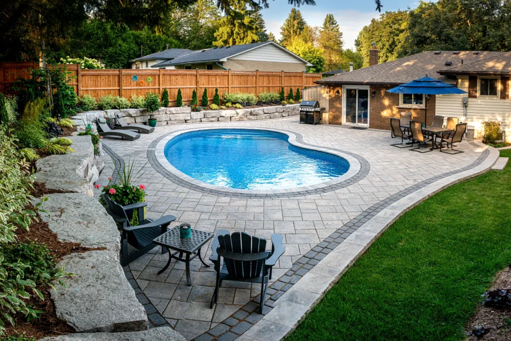 Elevated view of the backyard pool, patio, seating and armour stone landscape in Ancaster.