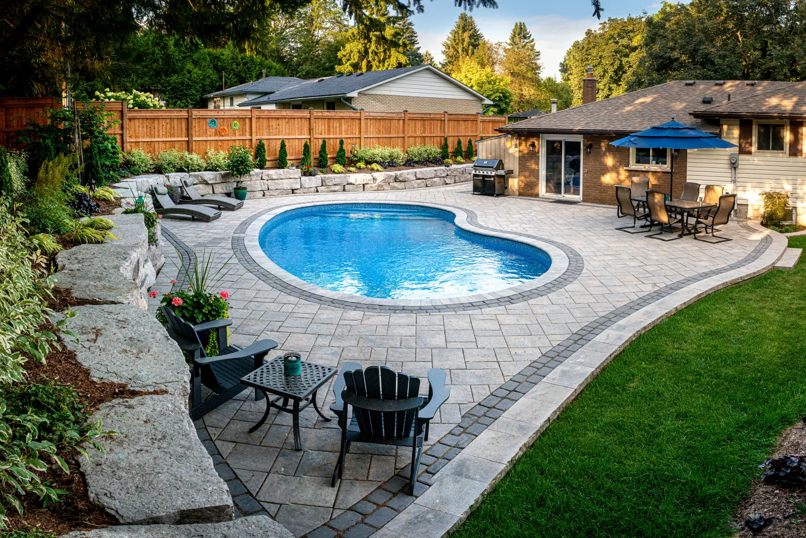 Elevated view of the backyard pool, patio, seating and armour stone landscape in Ancaster.
