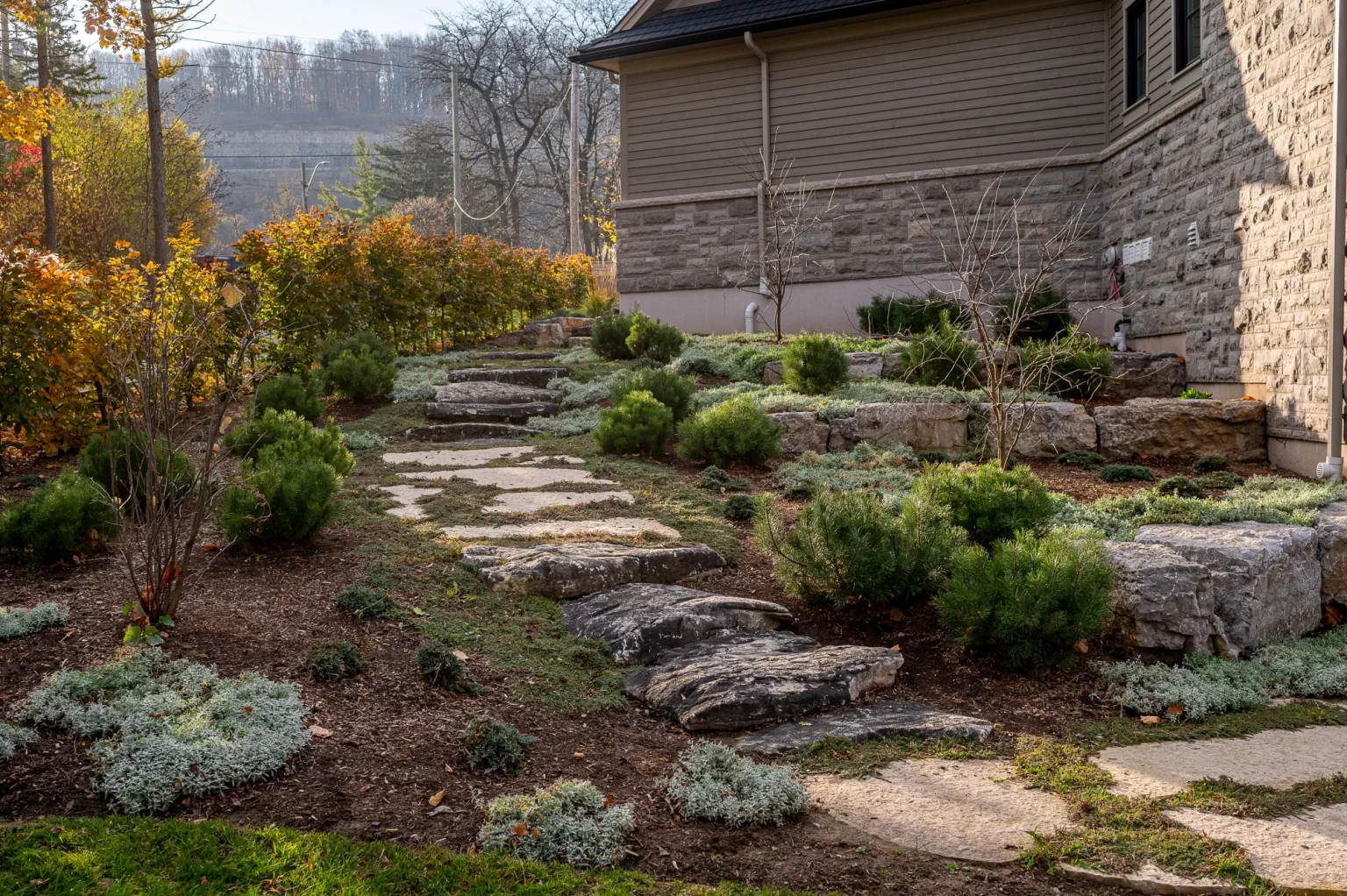 Stone garden steps and layered planting beside the home in autumn in Ancaster.