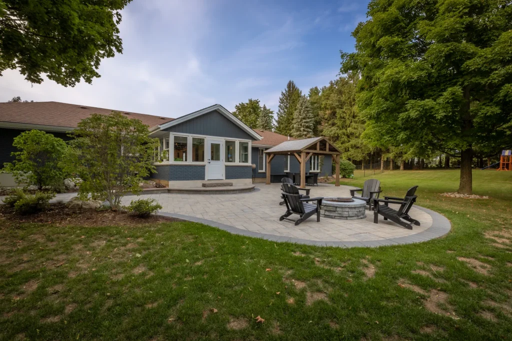 Brantford backyard with an interlock patio, circular fire pit and timber pergola.