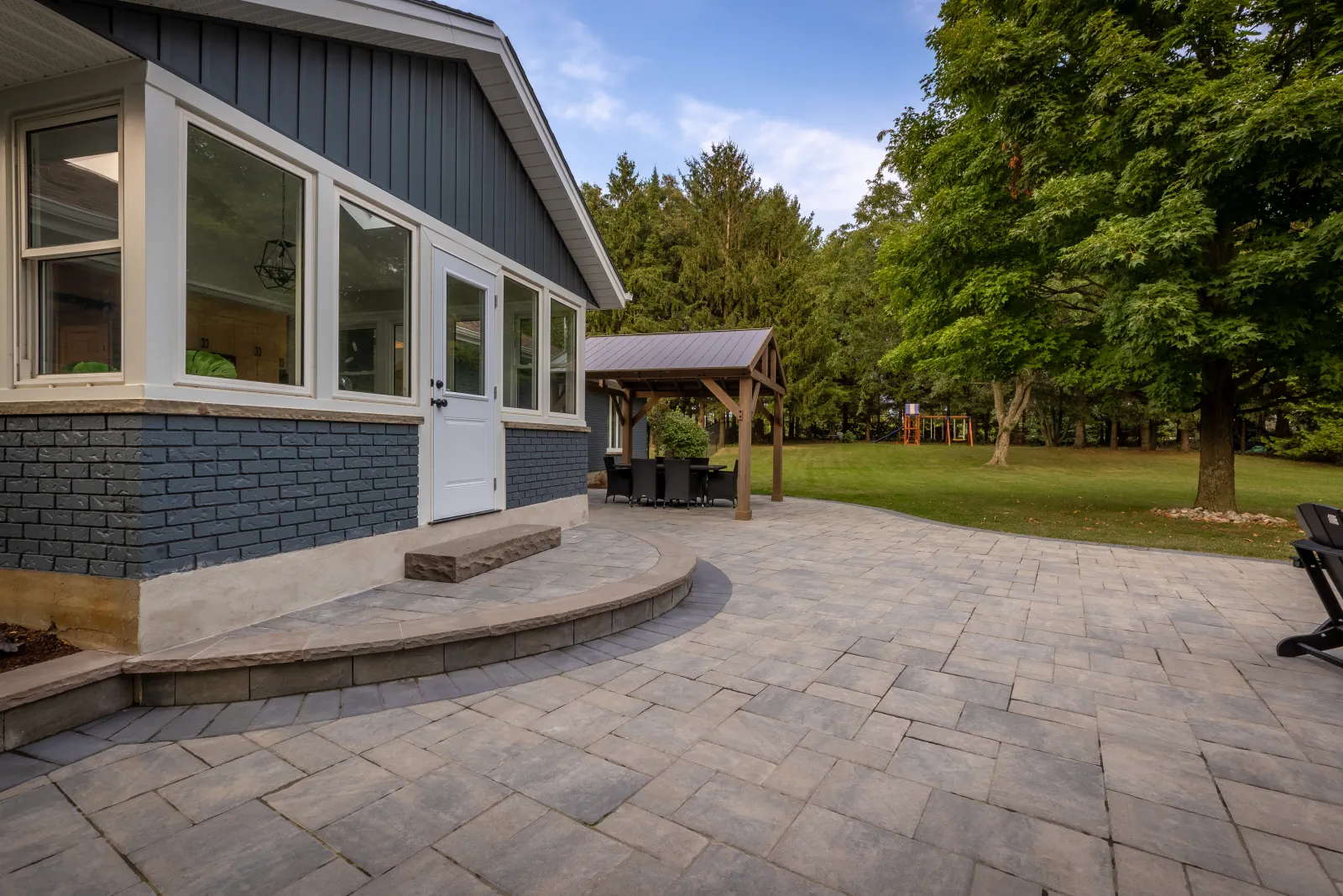 Interlock backyard patio with curved steps and a timber pergola in Brantford.