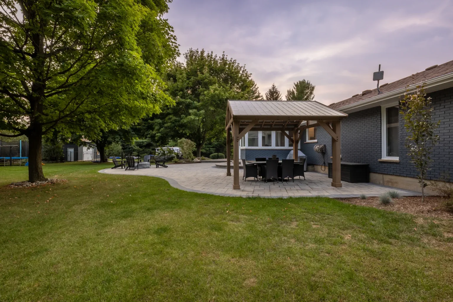Wide Brantford backyard view with a timber pergola and interlock patio.