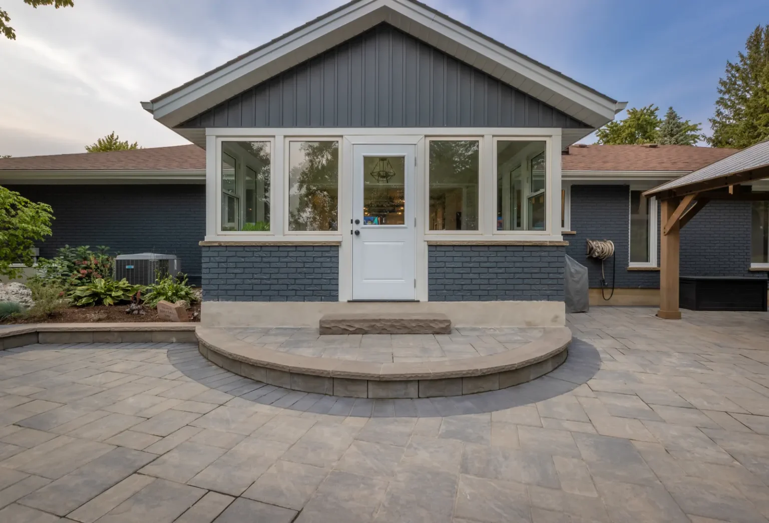 Curved interlock patio and raised backyard entrance steps in Brantford.