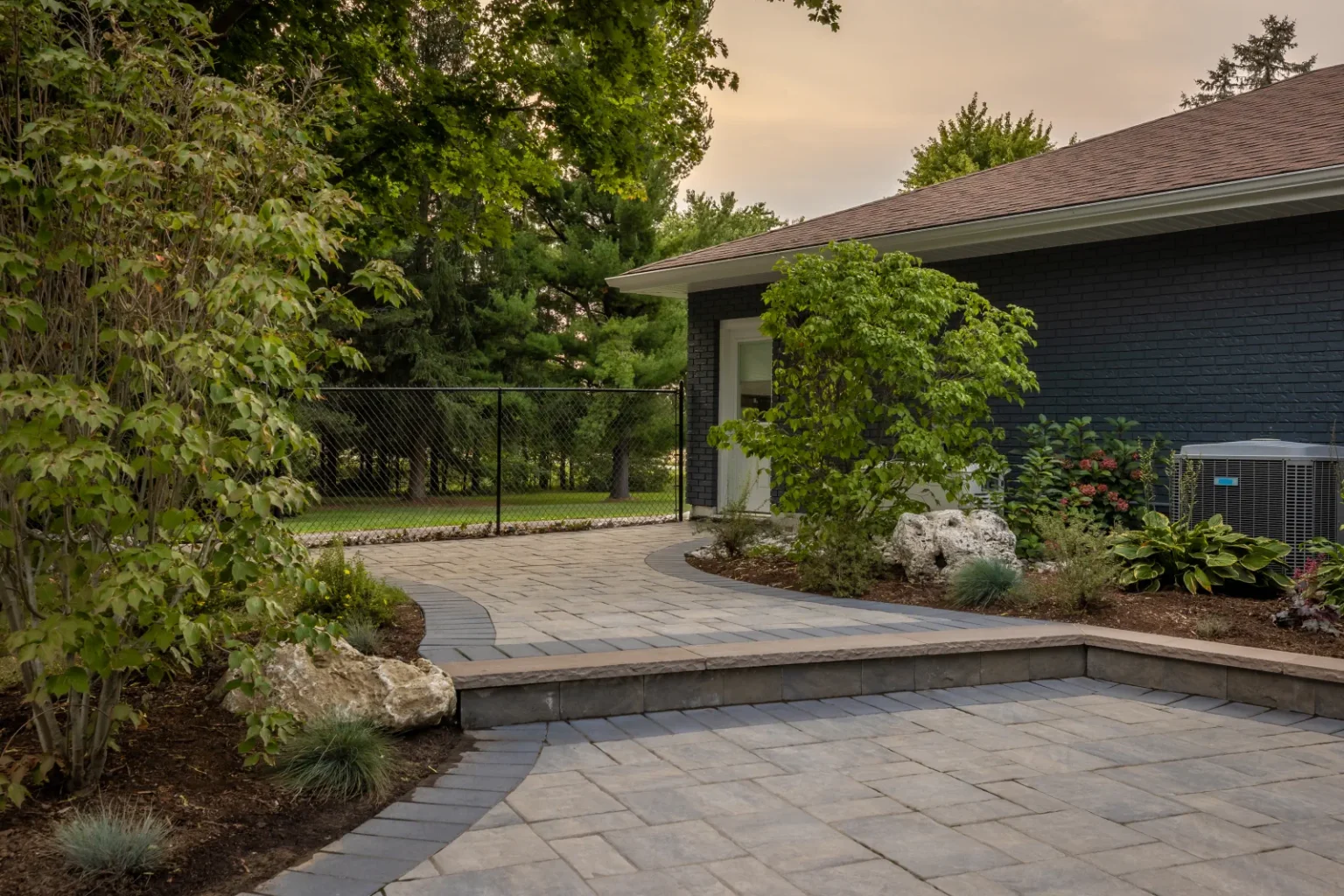 Interlock patio edge, steps and planted bed with boulders in Brantford.