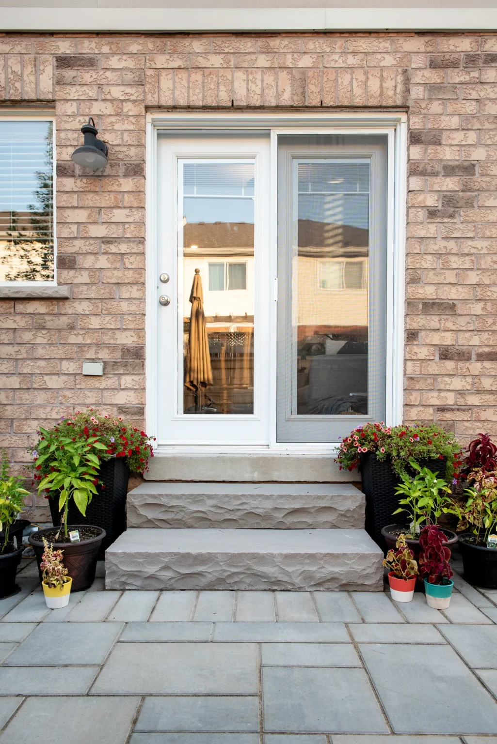 Backyard patio entrance with textured steps and interlock paving in Burlington.