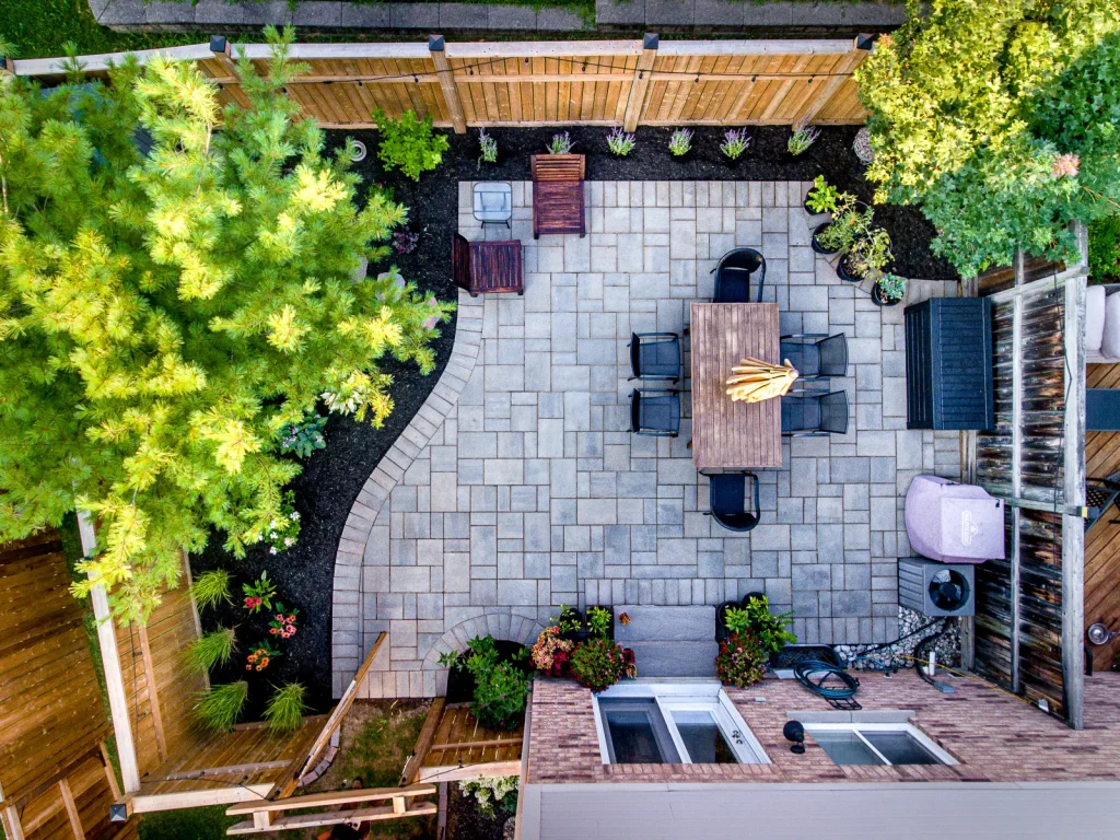 Aerial view of a small Burlington backyard with an interlock patio, dining area and planted borders.