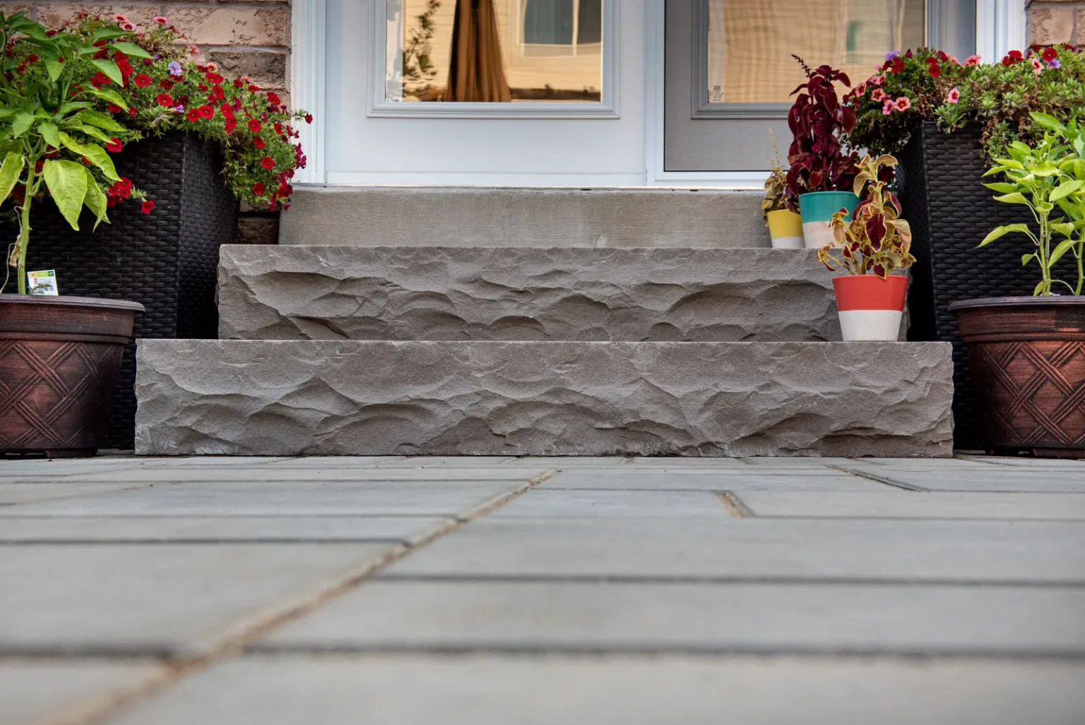 Close view of textured backyard steps meeting an interlock patio in Burlington.