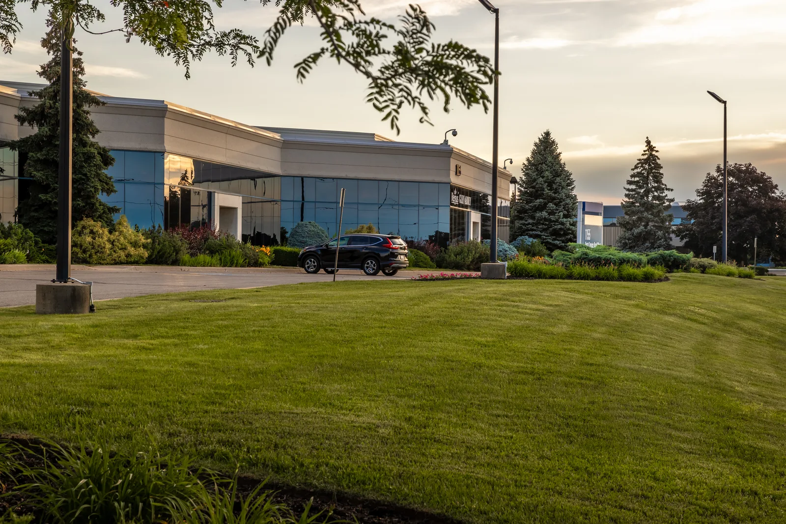 Maintained commercial lawn and office landscaping in warm evening light.