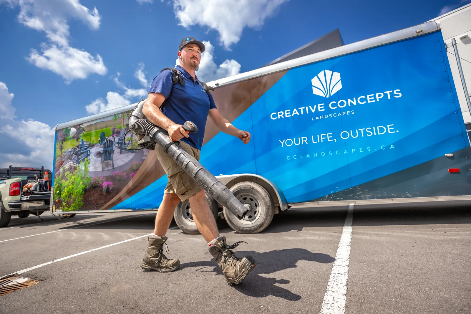 Creative Concepts crew member beside a branded company trailer.