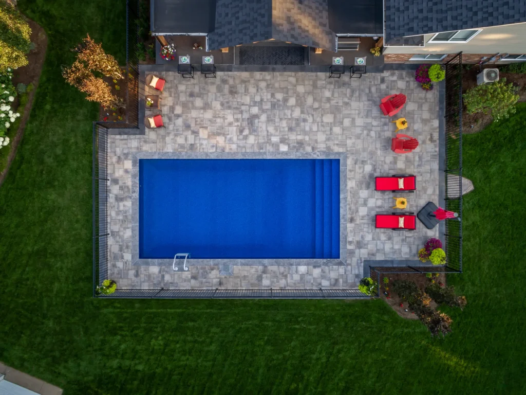 Top-down aerial view of a backyard pool and surrounding patio.
