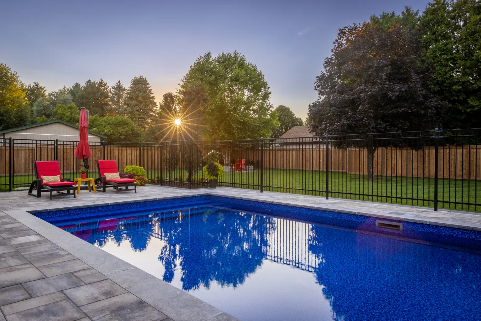 Backyard pool and interlock patio at sunset in Dundas.