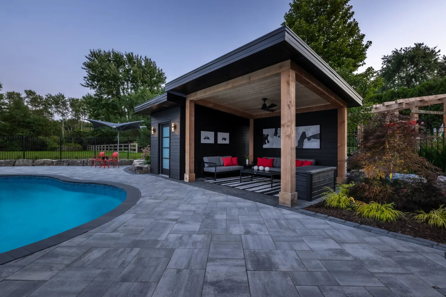 Contemporary pool cabana and lounge area framed by the curved pool in Dundas.
