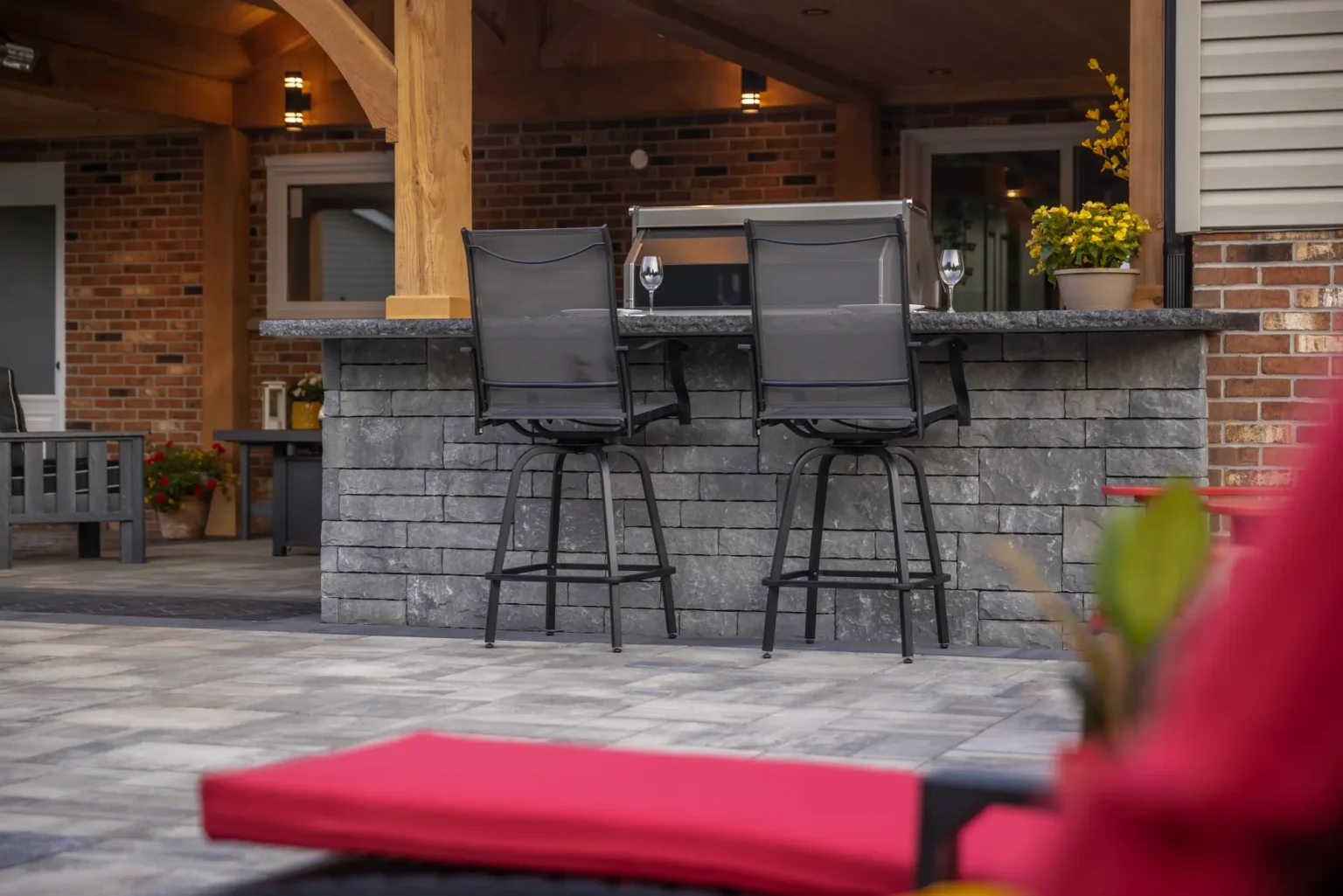 Covered outdoor bar with stone cladding and seating in a Dundas backyard.
