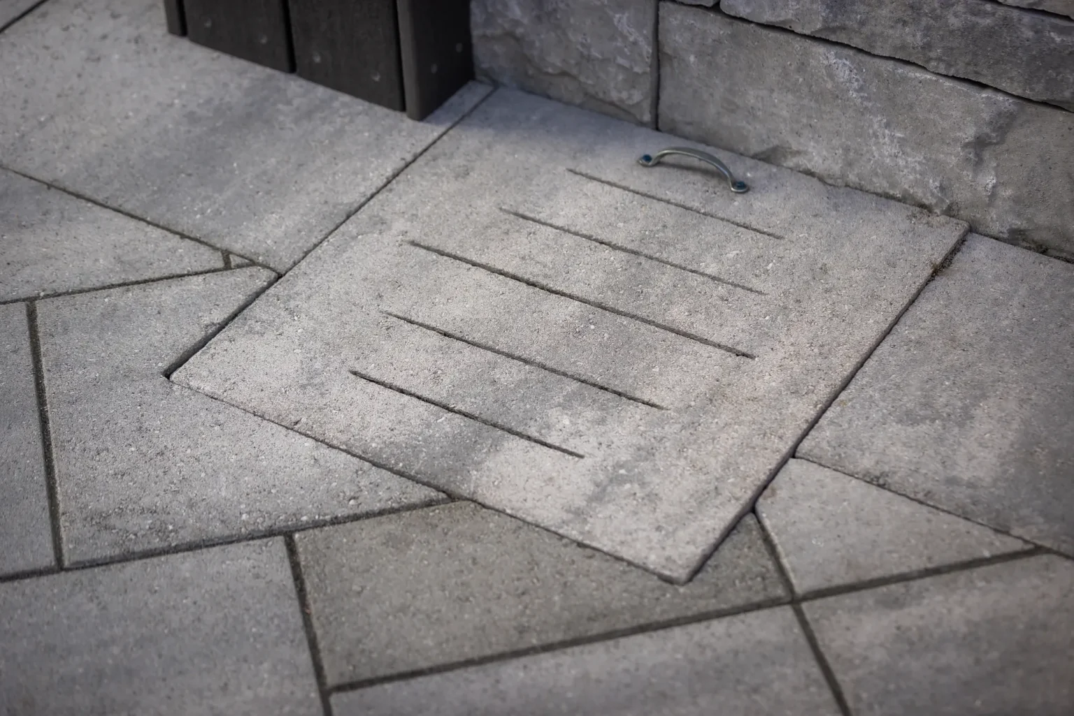 Close detail of slotted pavers and drainage beside the outdoor kitchen wall in Dundas.