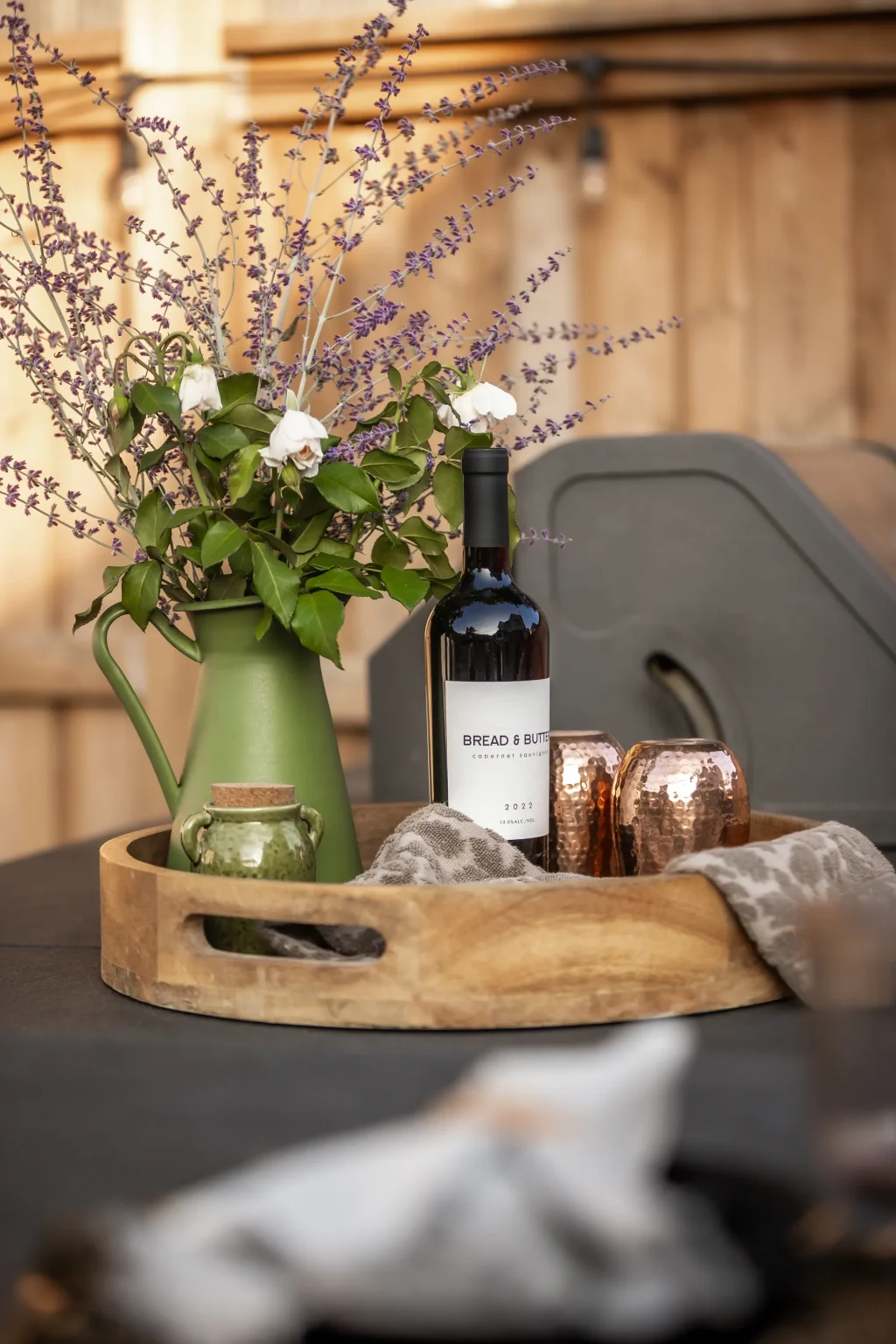 Portrait detail of the styled wine and floral tray in the outdoor living area in Dundas.