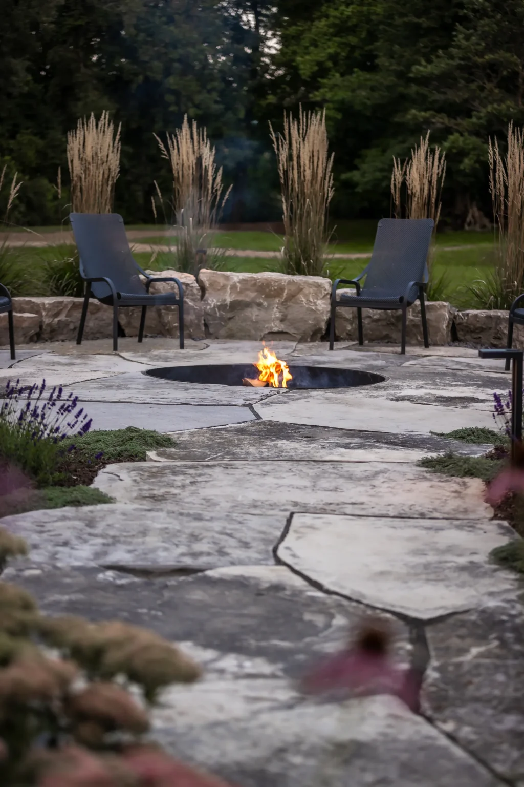 Portrait view down the natural-stone path toward the fire-pit seating circle in Dundas.