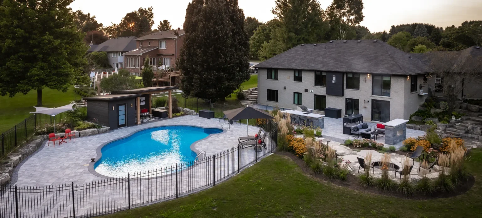 Oblique drone overview of the complete backyard pool and outdoor-living spaces in Dundas.
