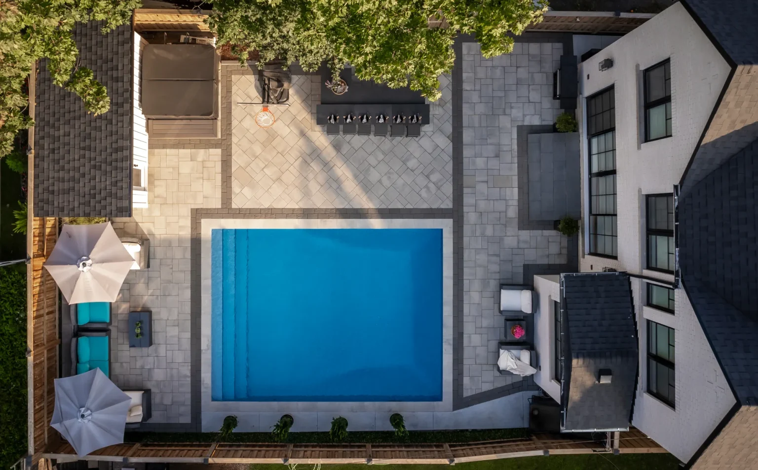 Top-down drone overview of the full backyard pool, patio and outdoor-living zones in Dundas.