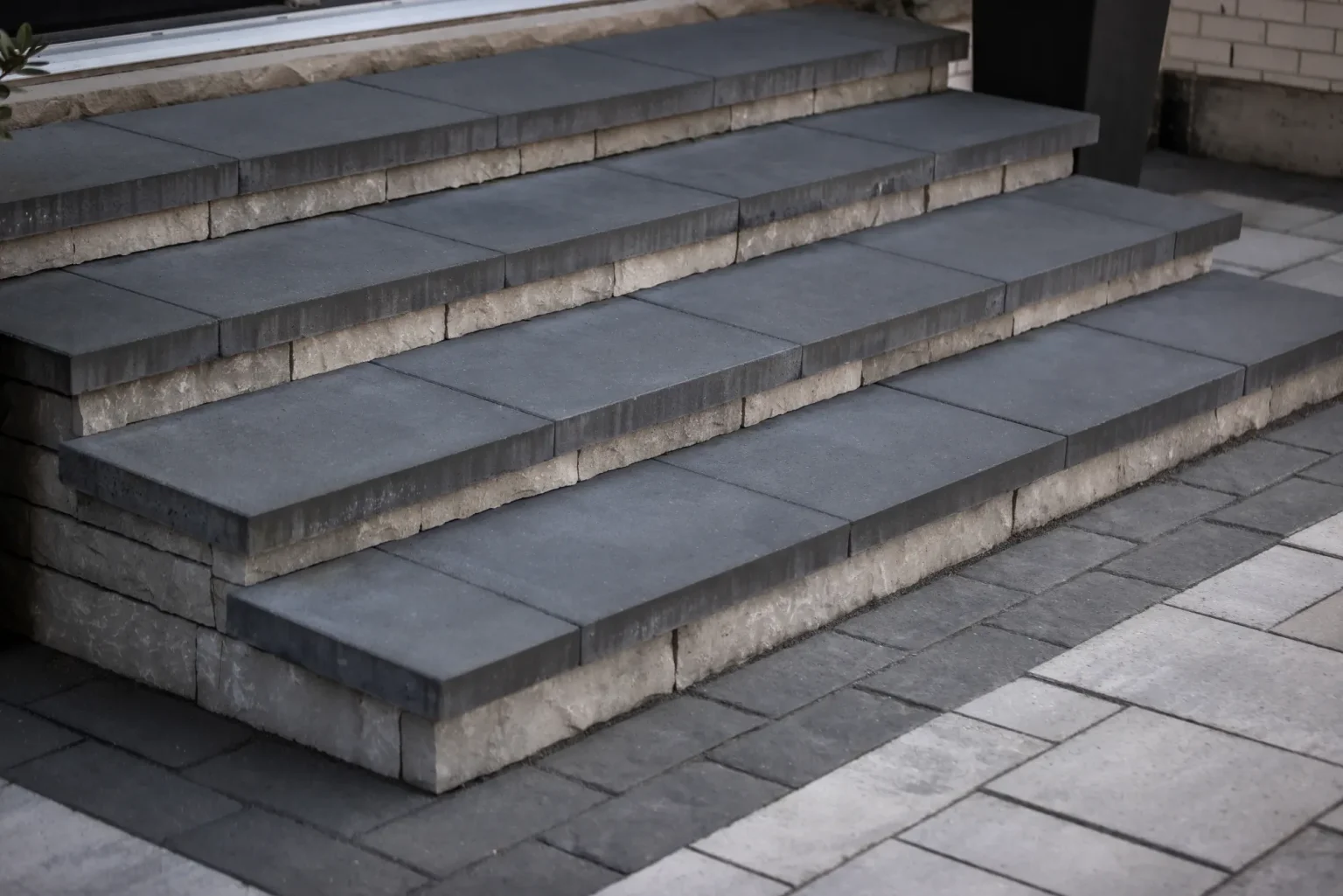 Close view of broad modern masonry steps leading from the home to the pool patio in Dundas.