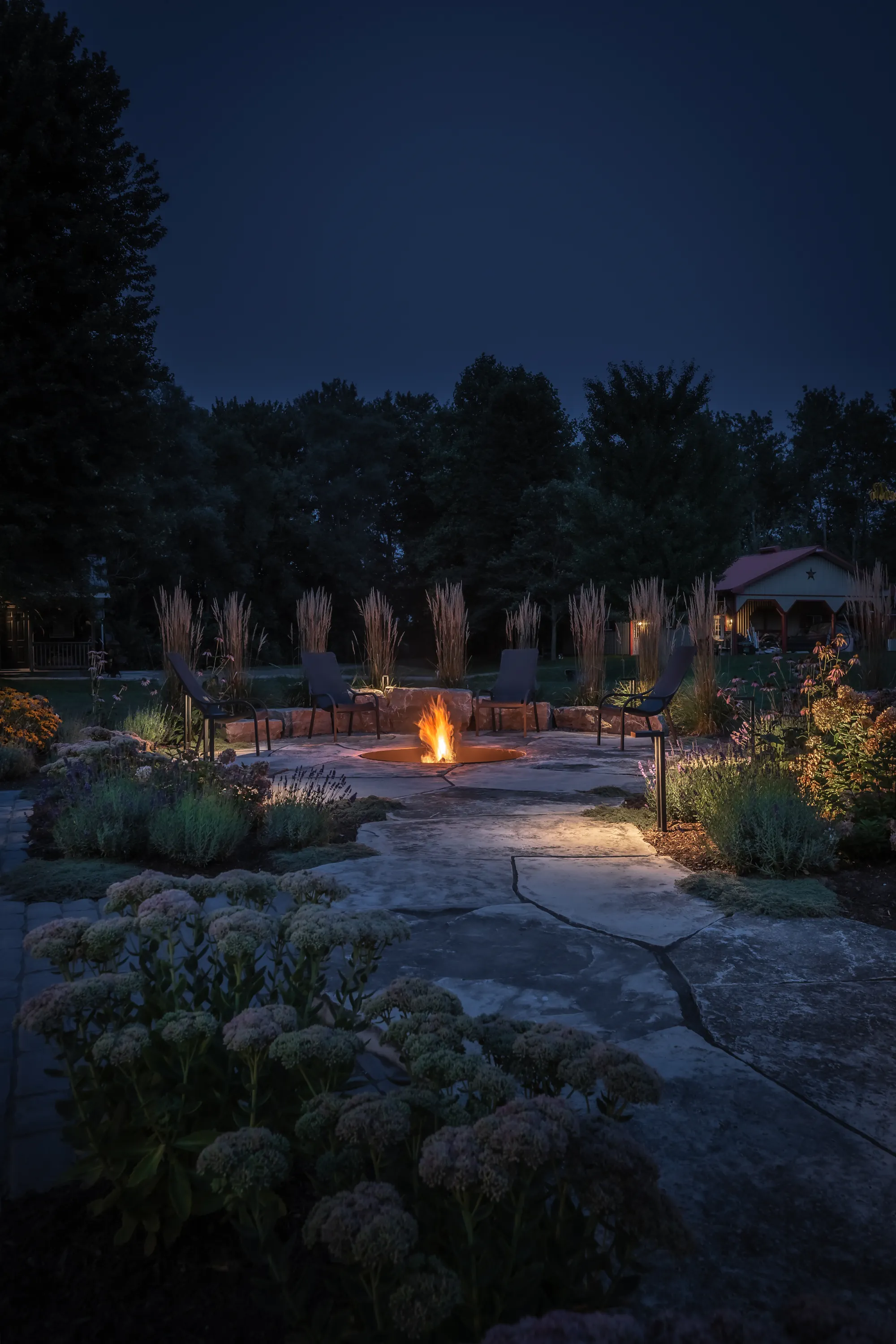 Portrait night view of the fire-pit garden and flowering borders in Dundas.