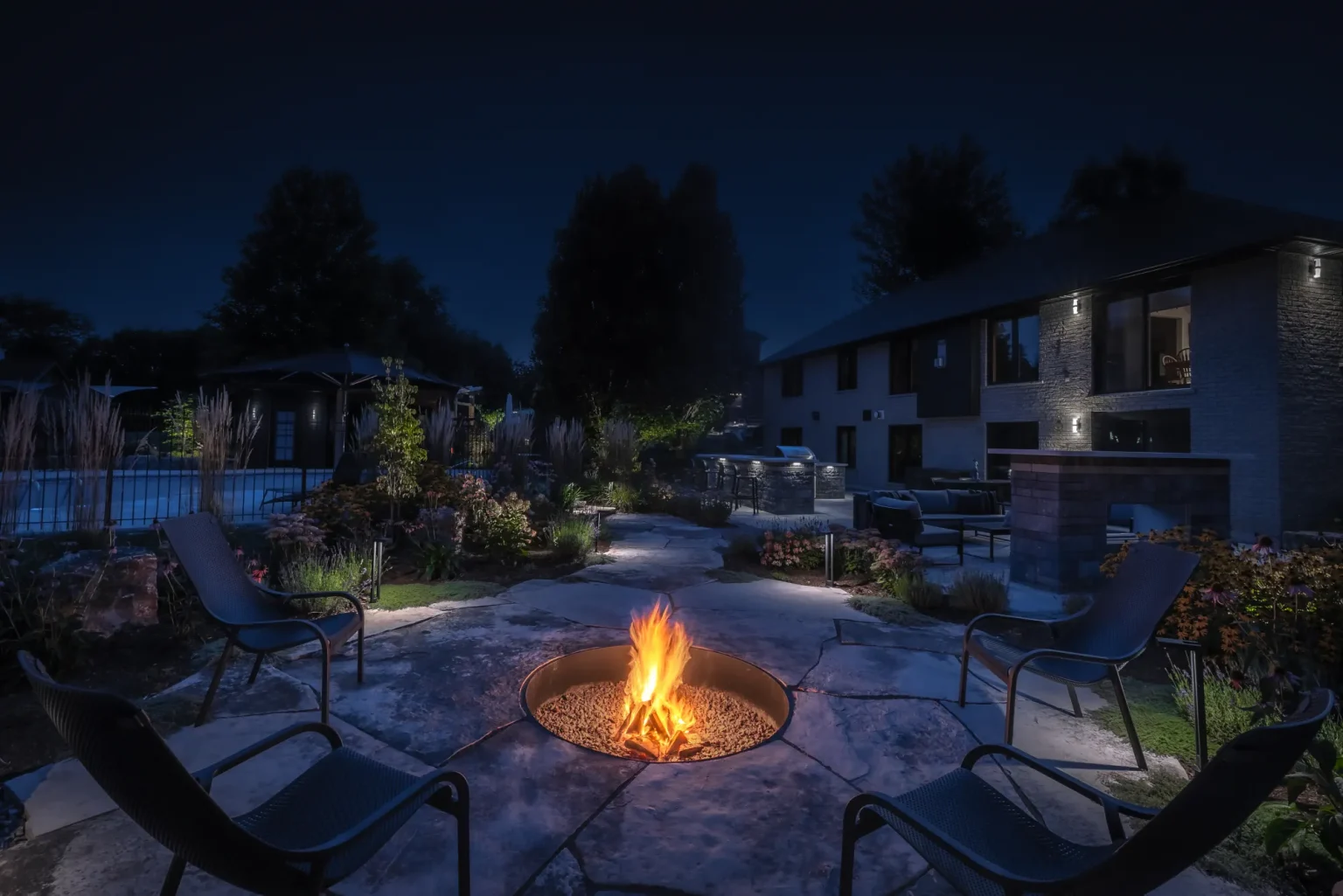 Night fire-pit seating circle with chairs and the home visible beyond in Dundas.