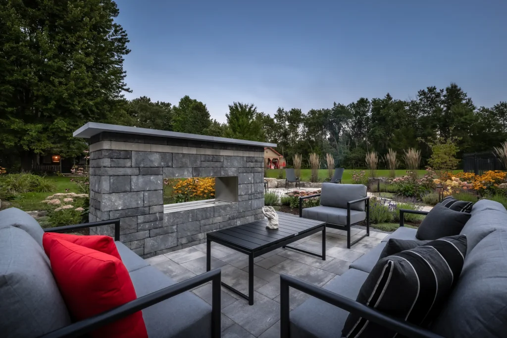 Outdoor lounge seating viewed through a low masonry privacy wall.