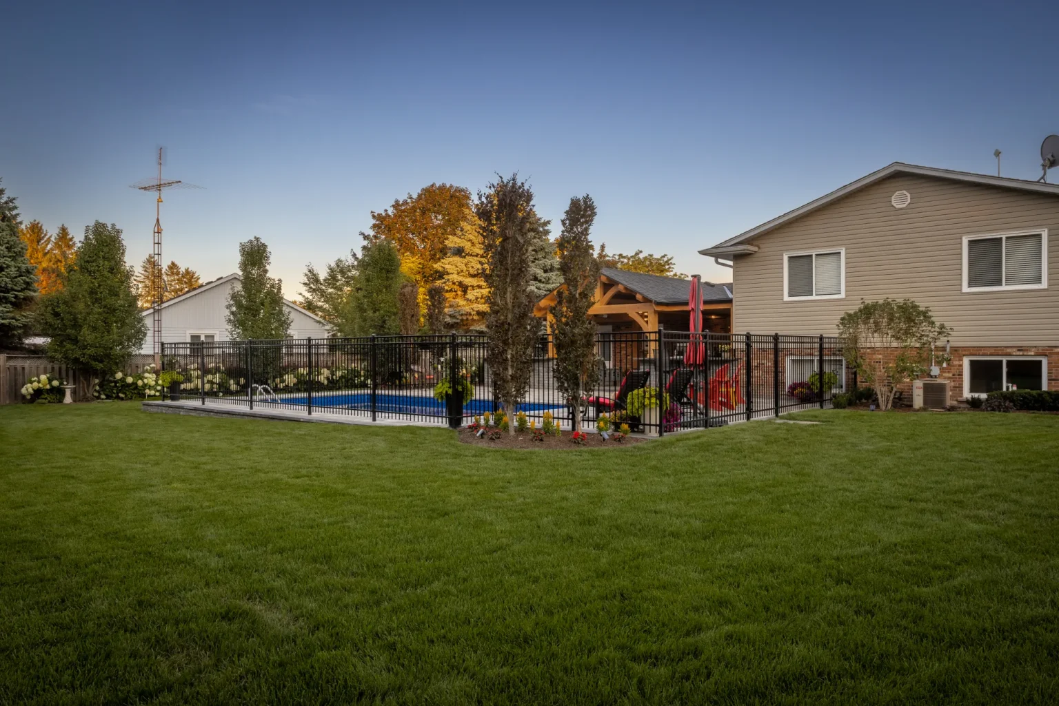 Lawn-side view of the pool, planting and timber-framed house extension in Dundas.