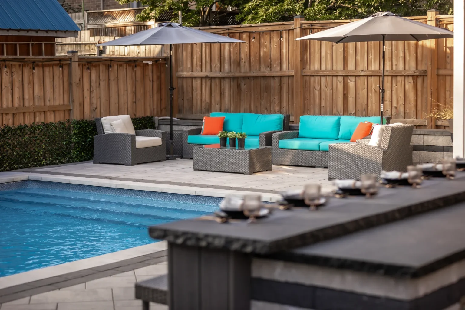 Poolside lounge scene with the outdoor bar in the foreground in Dundas.