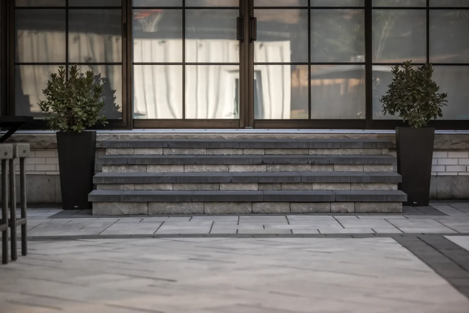 Straight-on view of the broad steps and modern paver patio at the rear of the home in Dundas.
