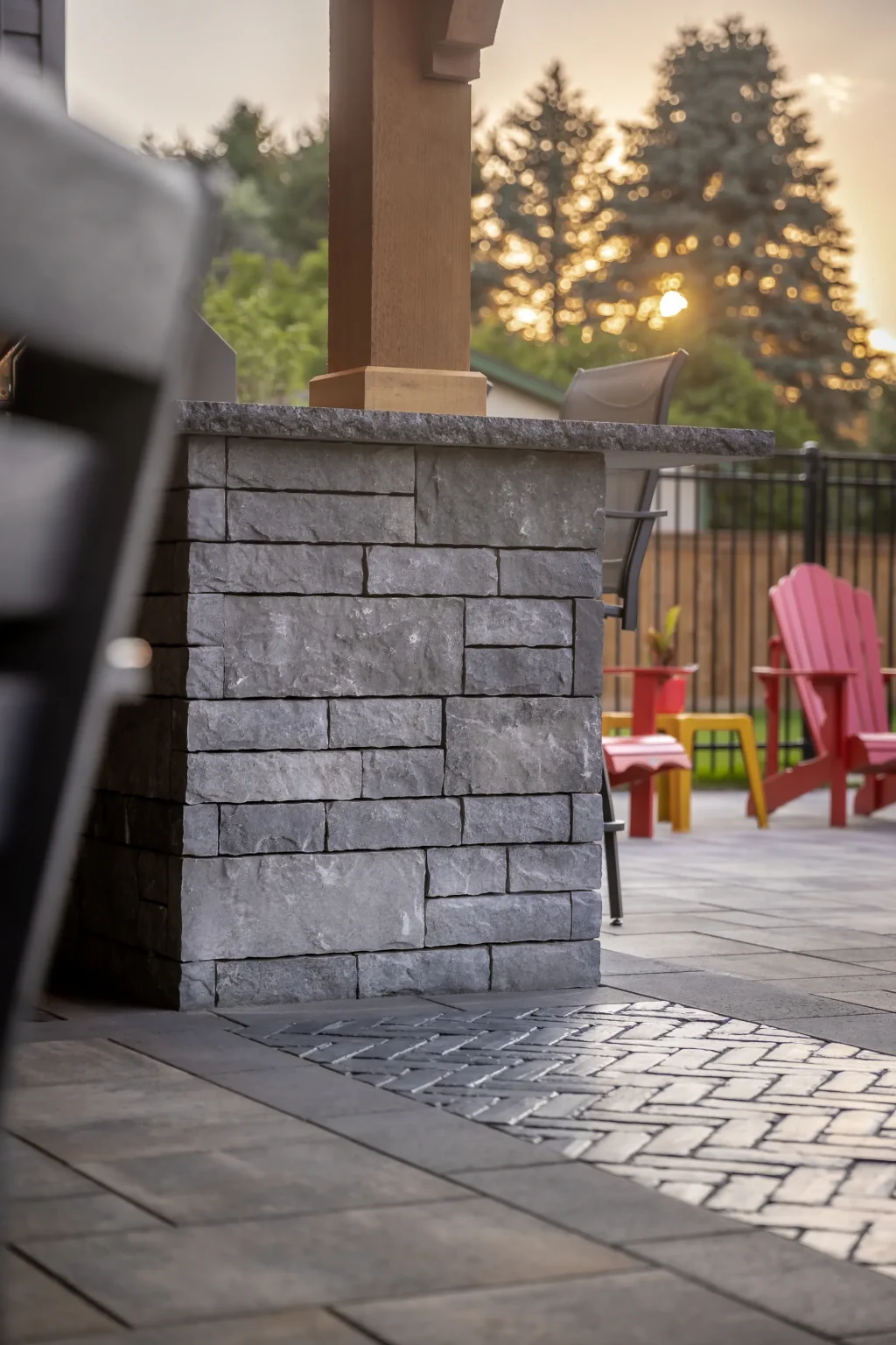 Stone-clad outdoor bar end and timber post beside the Dundas pool patio.
