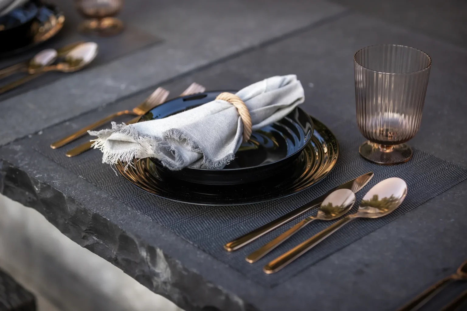 Styled outdoor dining place setting on a dark stone counter in Dundas.