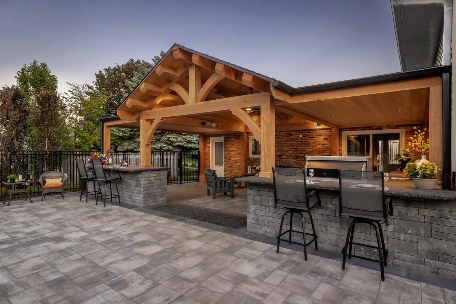 Wide view of the timber-framed house extension, stone-clad bar and patio in Dundas.