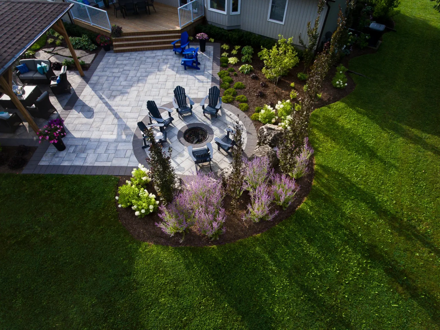 Closer aerial view of the circular fire-pit seating area and surrounding flowering border in Flamborough.