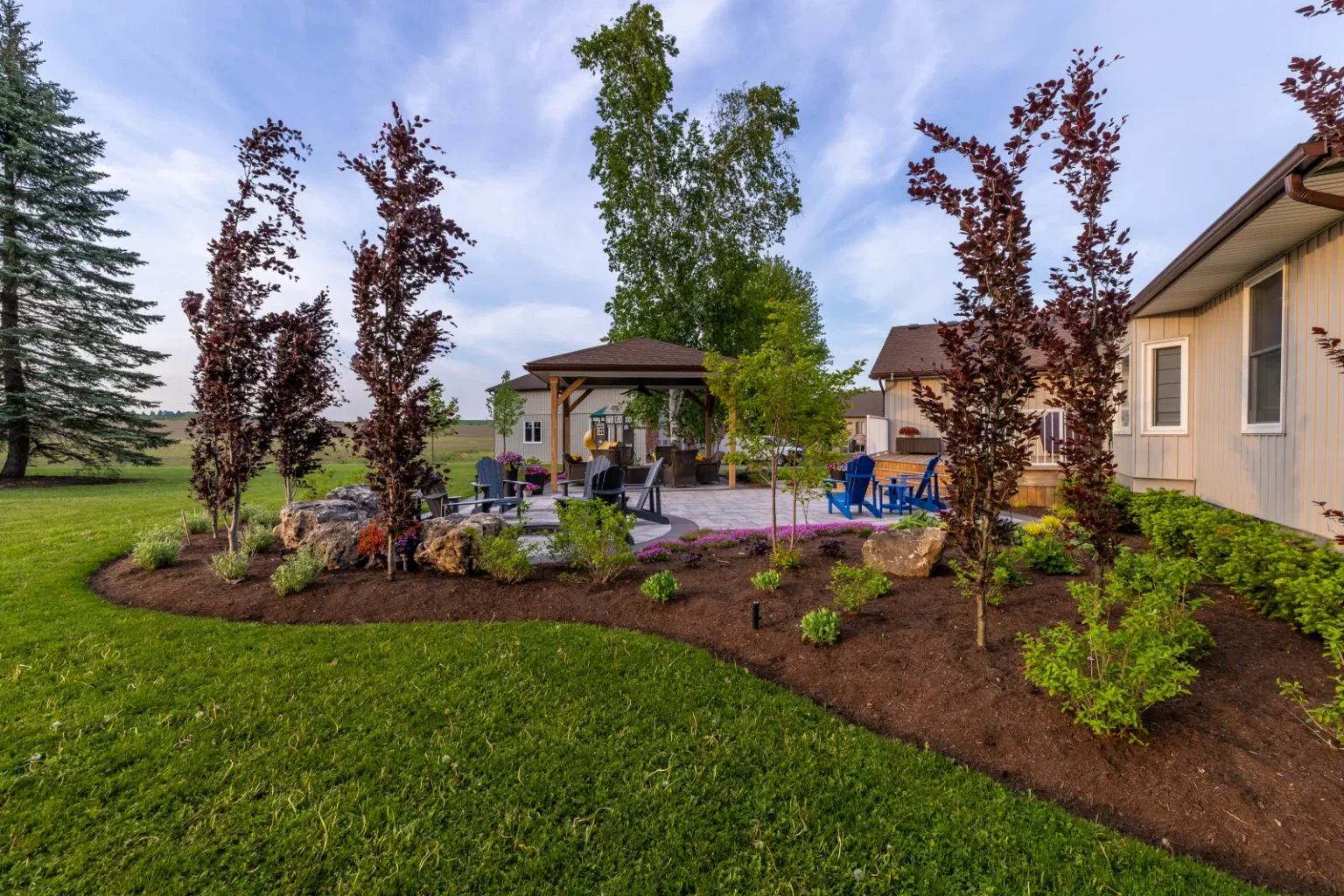Broad backyard garden view showing new trees, planting beds and gathering spaces in Flamborough.