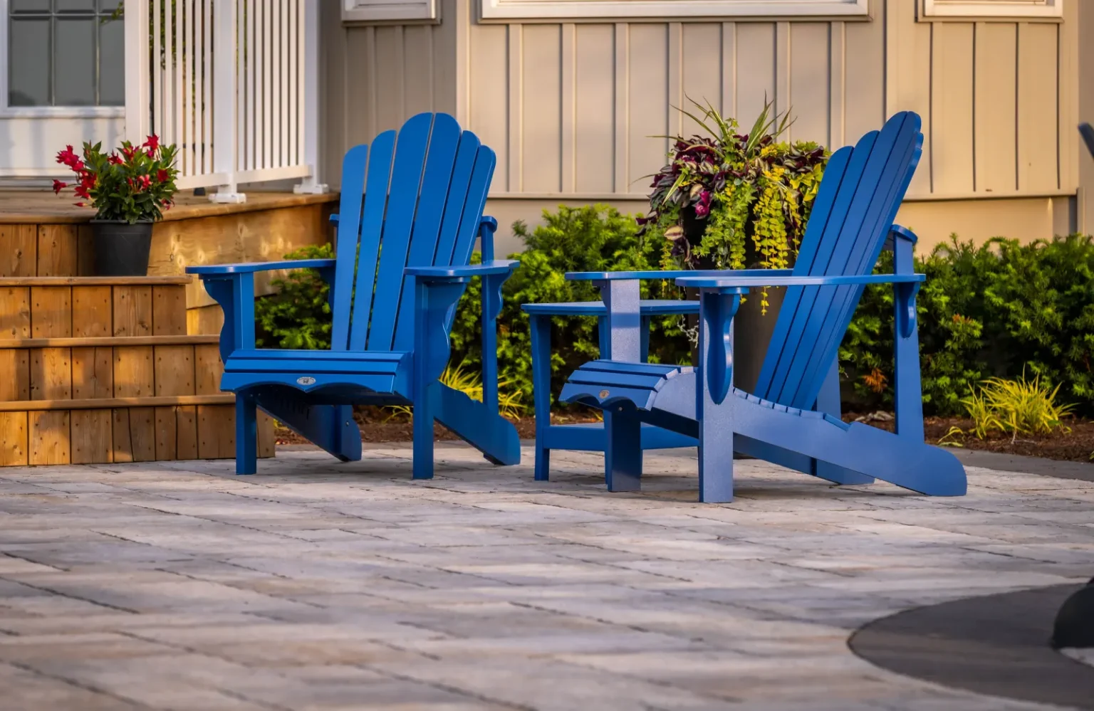 Close view of blue Adirondack chairs on the paver patio beside the house in Flamborough.