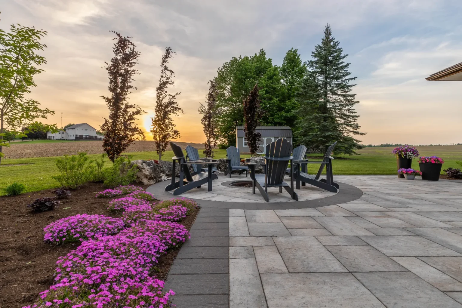 Fire-pit circle and flowering garden at sunset beside the main patio in Flamborough.