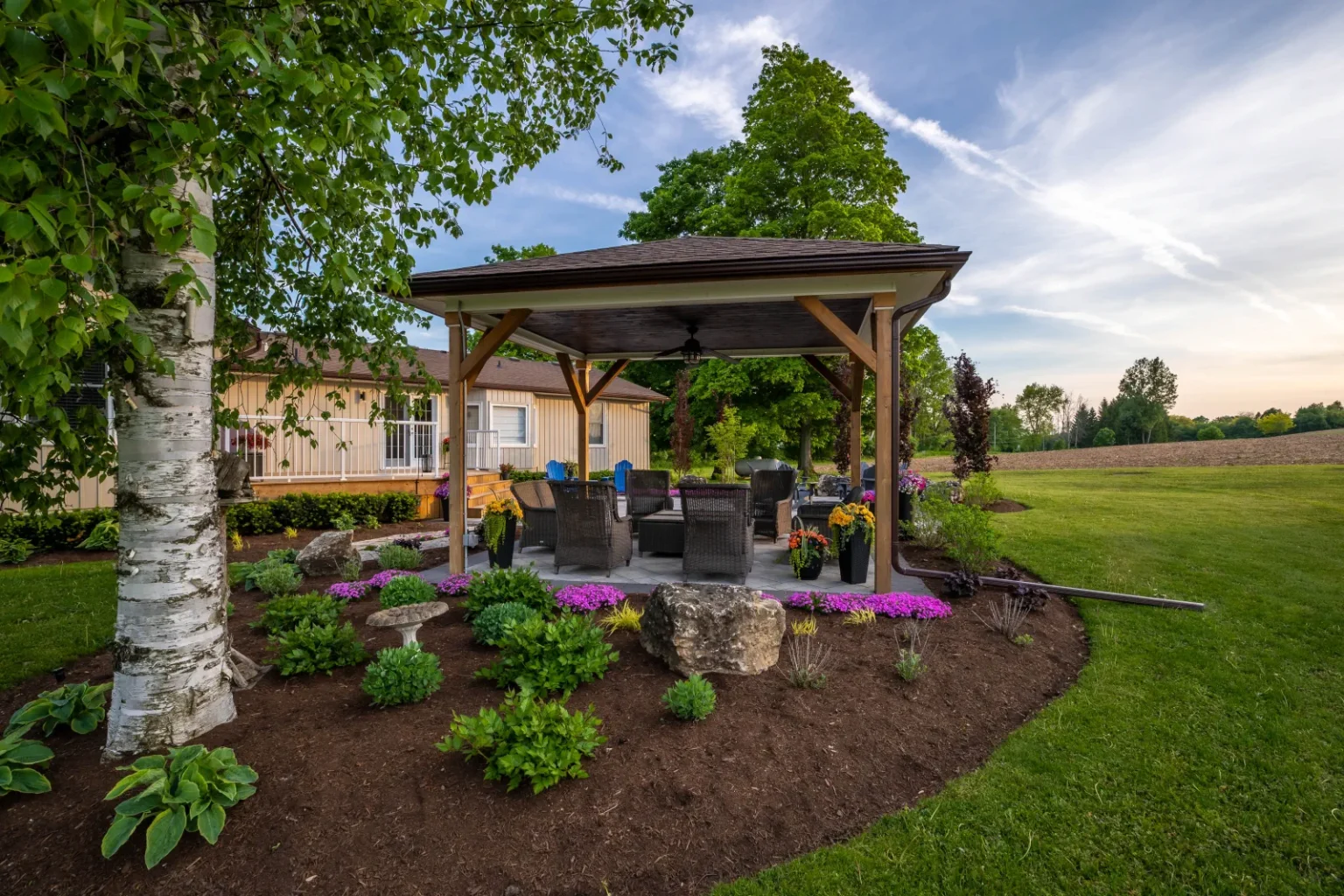 Wide side view of the pavilion, layered garden beds and open lawn in Flamborough.