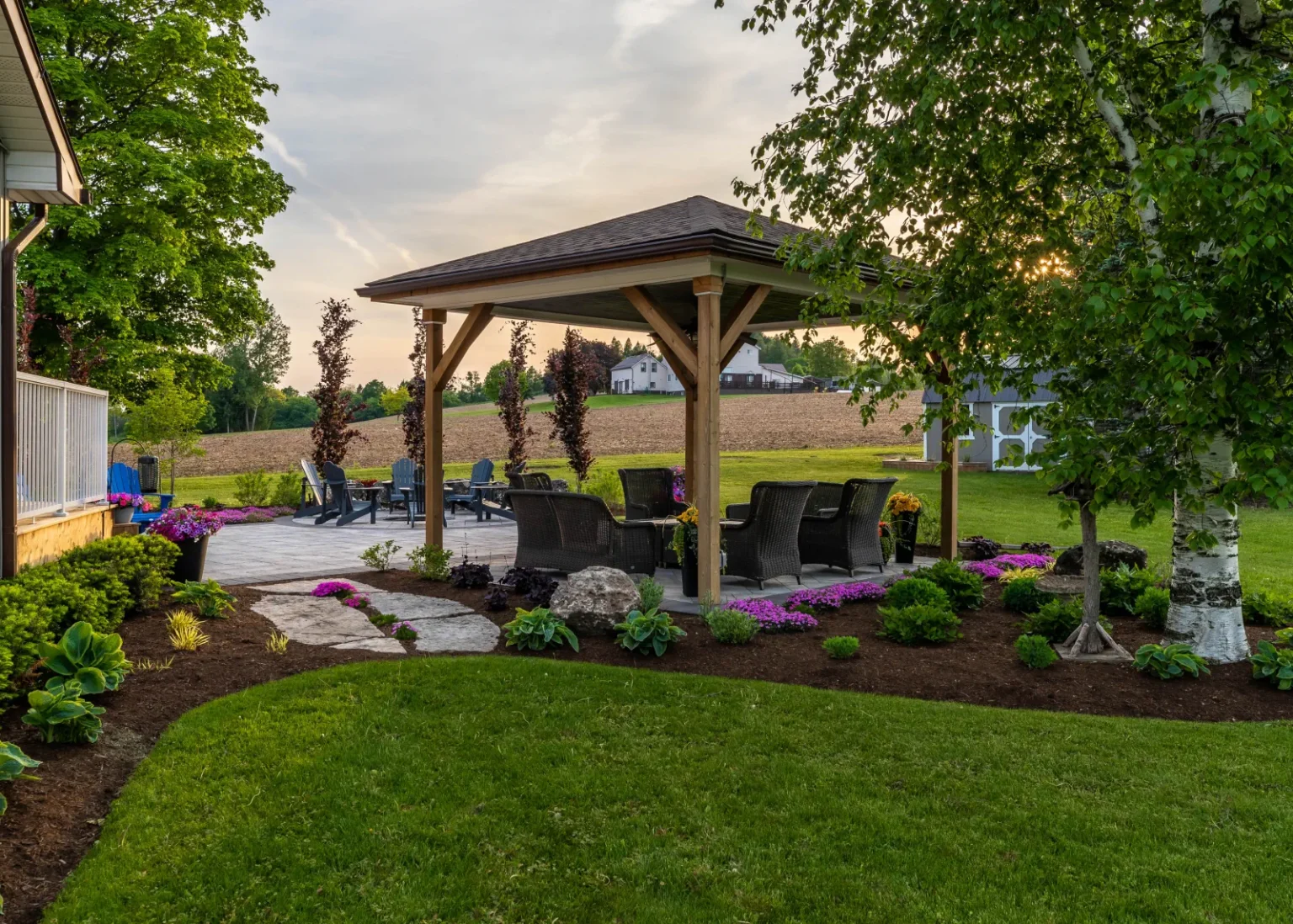 Timber pavilion surrounded by mulched planting beds and ornamental shrubs in Flamborough.
