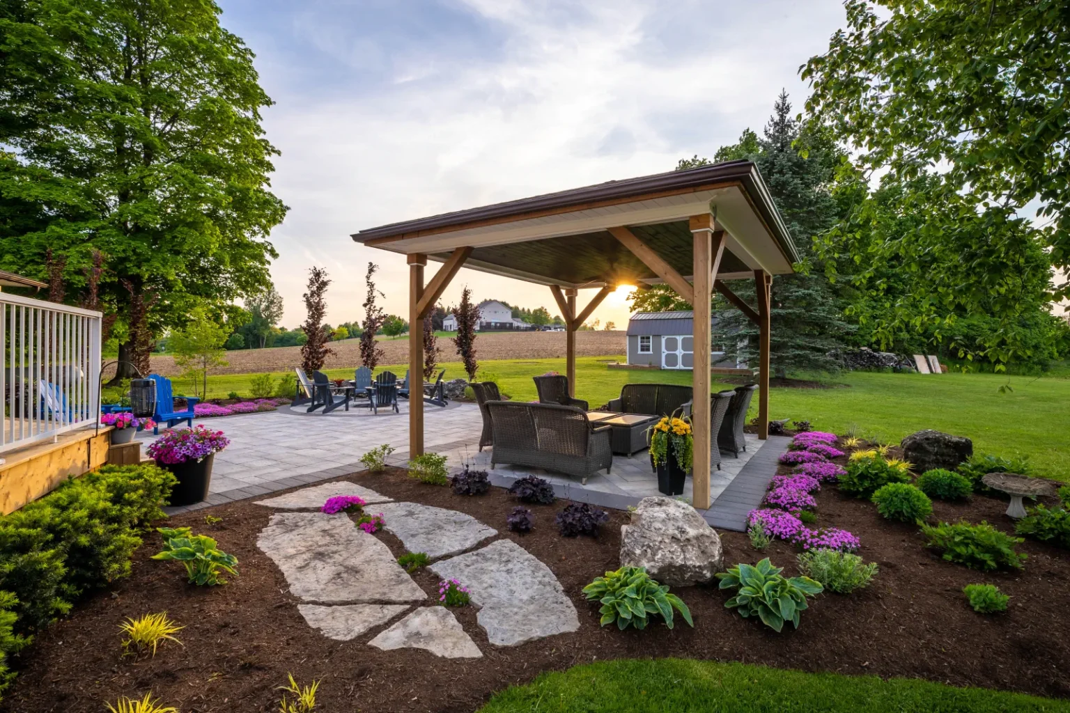 Timber pavilion and natural-stone stepping path through the planted backyard in Flamborough.