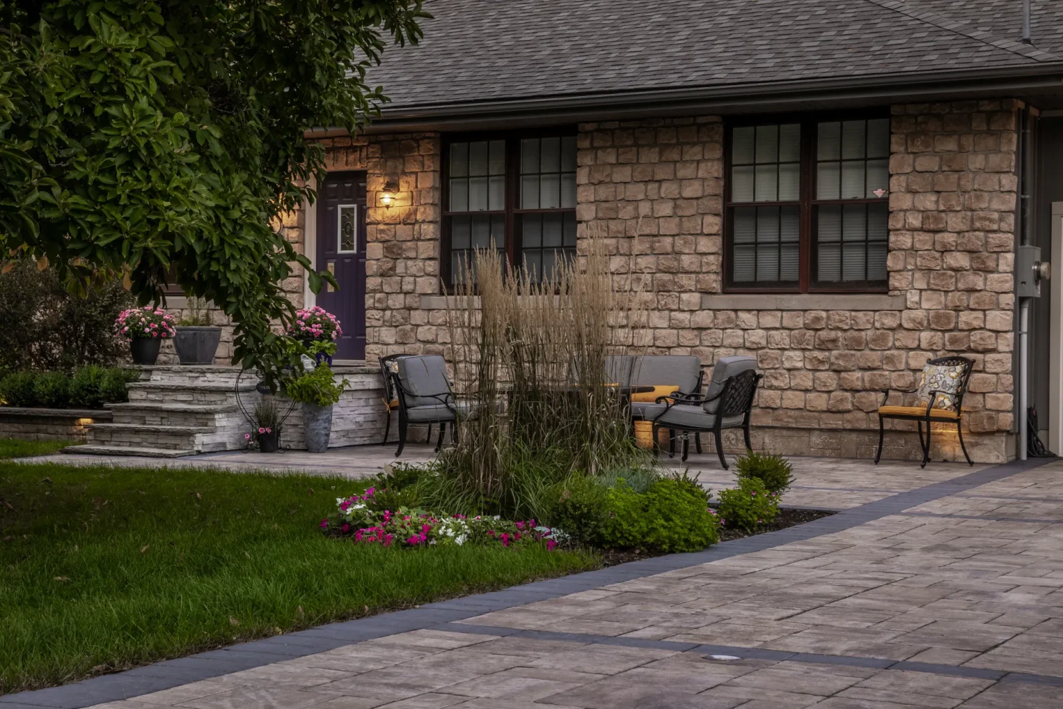 Completed front patio and driveway edge beside the stone house and lawn in Hamilton.