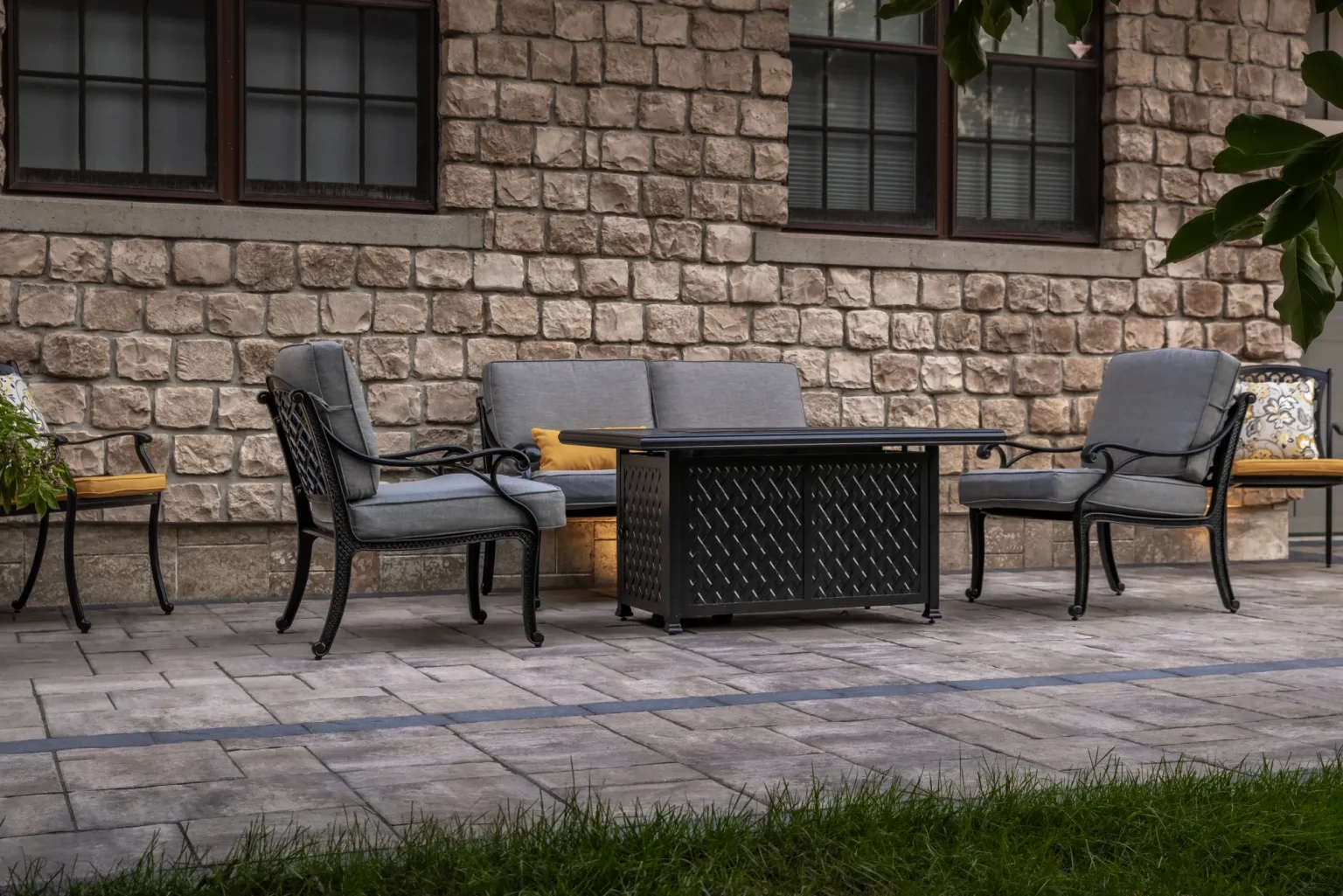 Closer front patio seating area with patterned pavers against the stone home in Hamilton.
