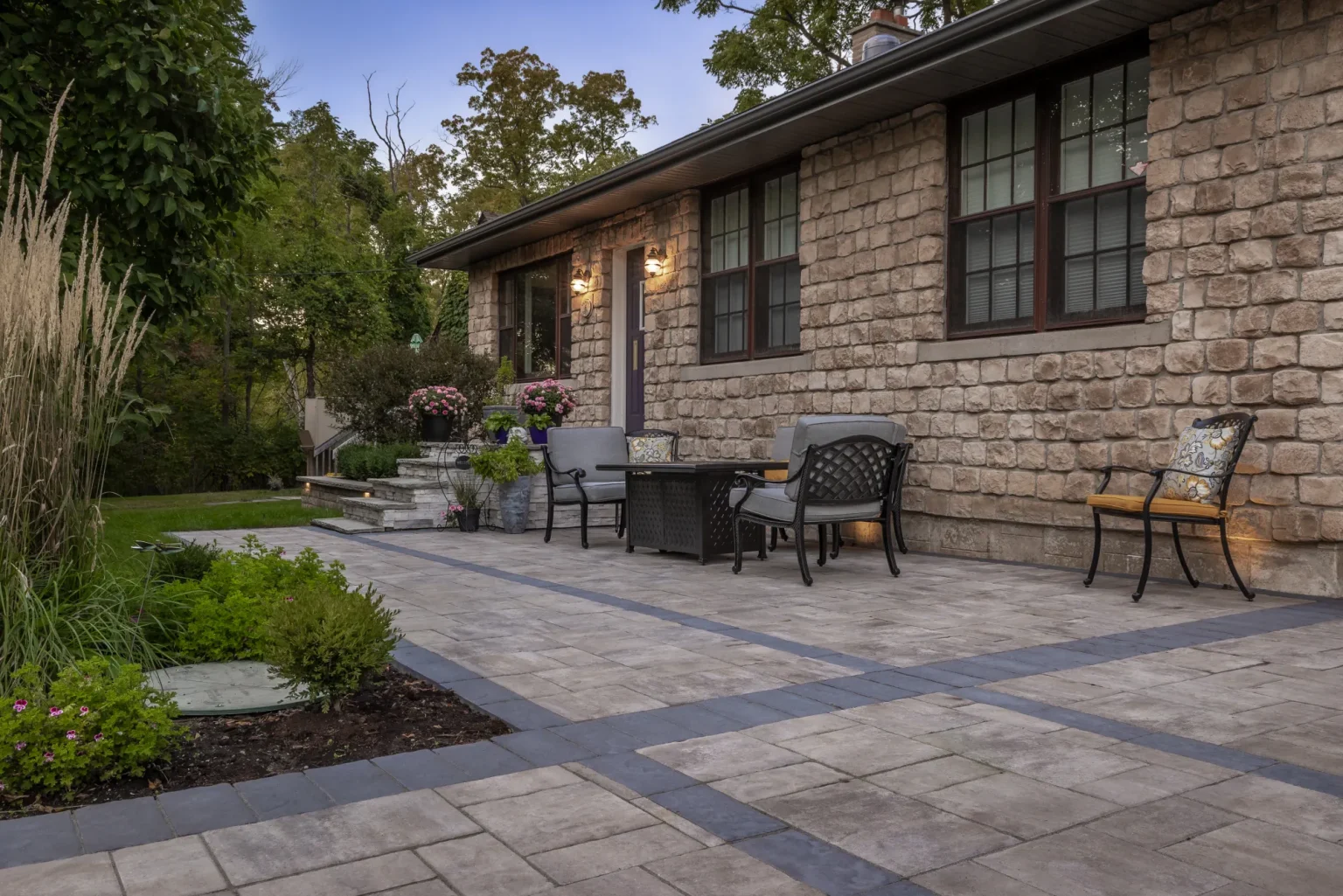 Wide completed front patio with seating, steps and landscaped edge in Hamilton.