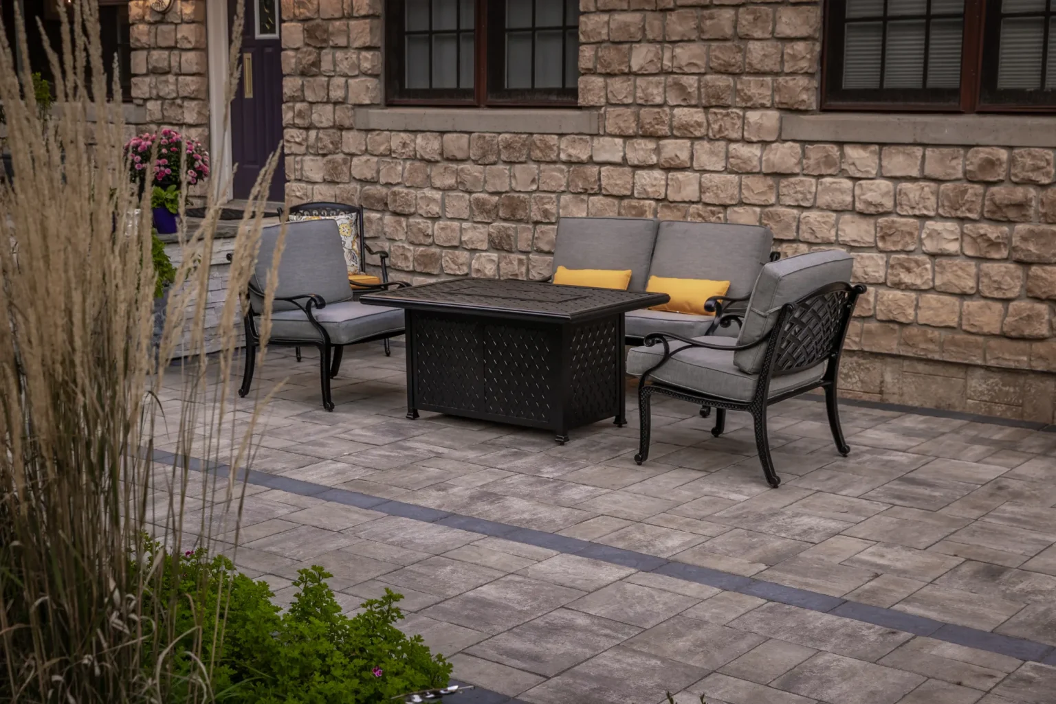 Close view of outdoor seating on the patterned front patio beside the stone wall in Hamilton.